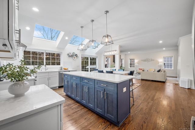 kitchen with dark wood-type flooring, open floor plan, dishwasher, light countertops, and blue cabinets