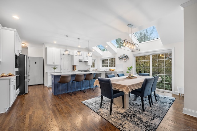 dining area with lofted ceiling with skylight, recessed lighting, baseboards, and dark wood-type flooring