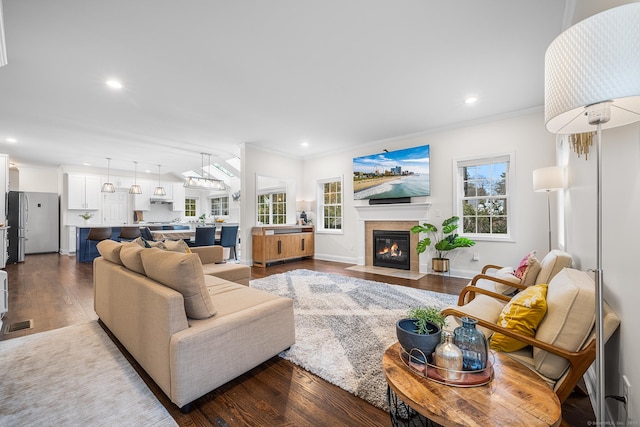 living area with recessed lighting, dark wood-style floors, and ornamental molding