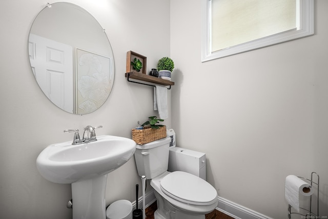 half bathroom with toilet and baseboards