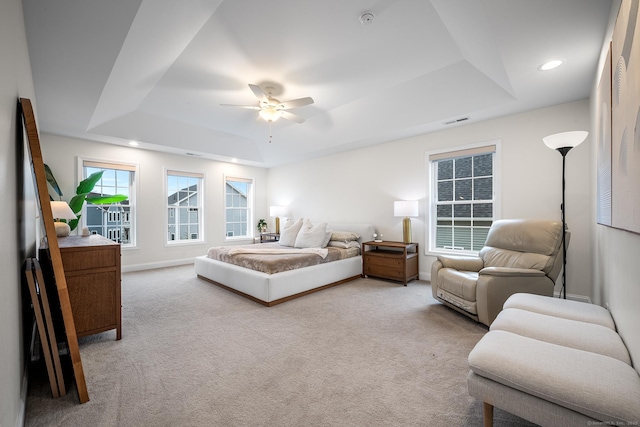 carpeted bedroom featuring visible vents, baseboards, a tray ceiling, recessed lighting, and a ceiling fan