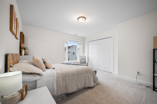 bedroom with visible vents, baseboards, a closet, and light carpet