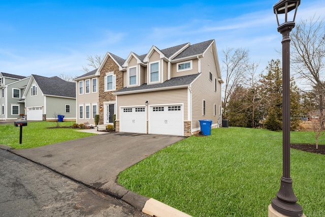 view of front of home featuring a front yard, an attached garage, stone siding, and driveway