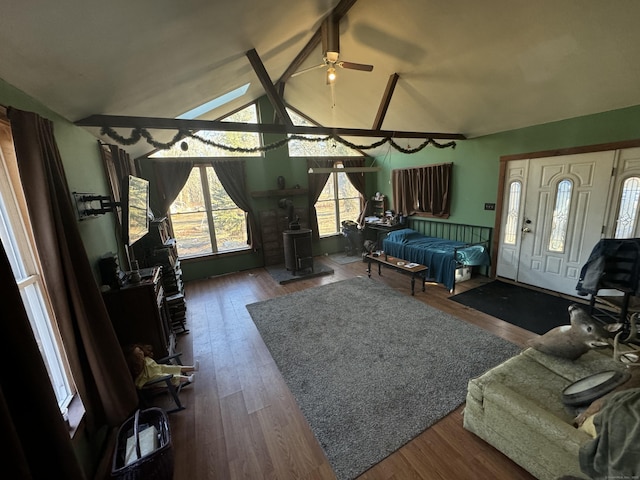 living room featuring a ceiling fan, lofted ceiling with beams, and wood finished floors