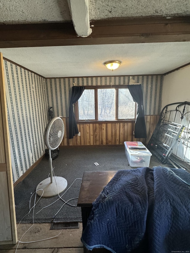 carpeted bedroom with beam ceiling, a textured ceiling, and wallpapered walls