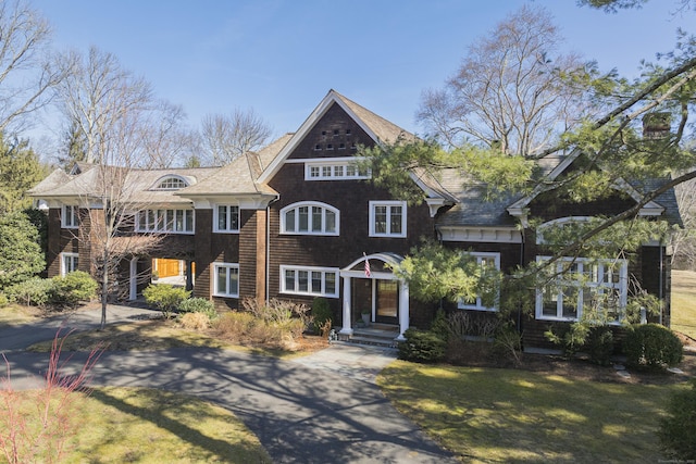 shingle-style home featuring a front yard