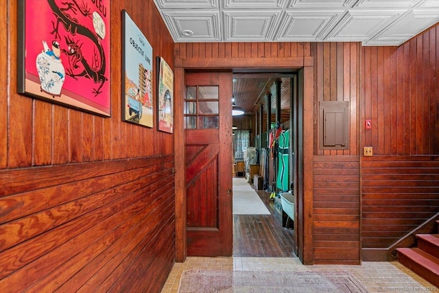 corridor with stairway, electric panel, wood walls, and an ornate ceiling