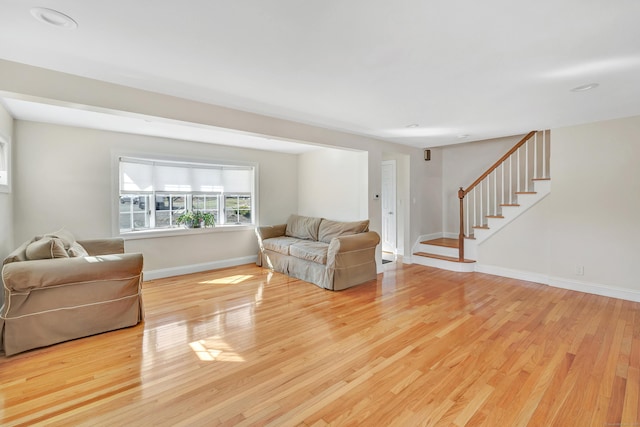 living area featuring stairway, wood finished floors, and baseboards