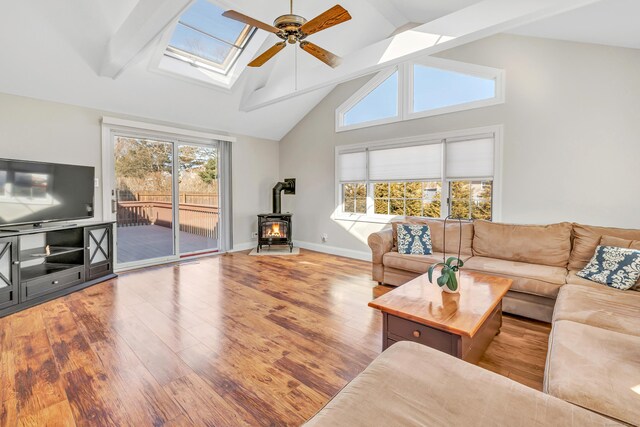 living area with a wood stove, wood finished floors, and a wealth of natural light