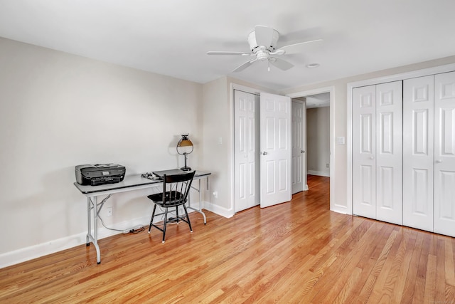 home office featuring a ceiling fan, light wood-type flooring, and baseboards