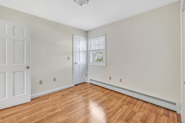 unfurnished room with light wood-type flooring, a baseboard radiator, and baseboards