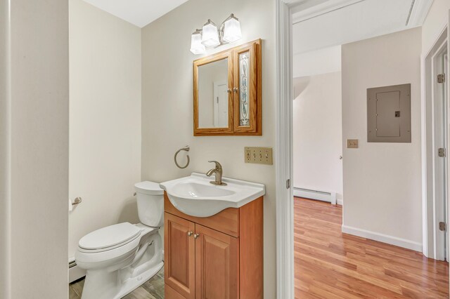 half bathroom with electric panel, toilet, wood finished floors, and a baseboard radiator