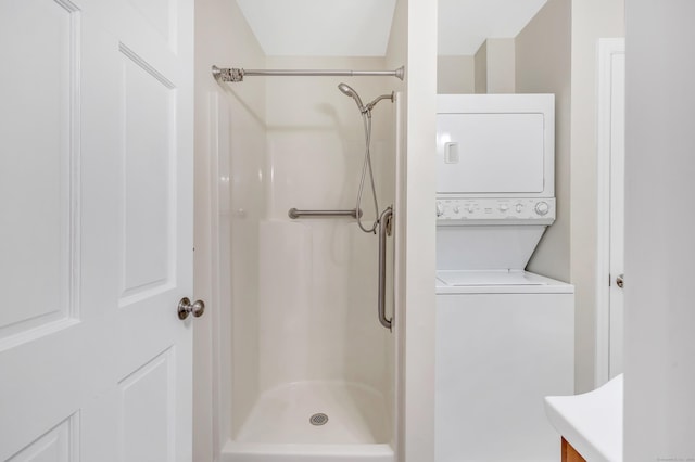 bathroom featuring stacked washer and clothes dryer and walk in shower