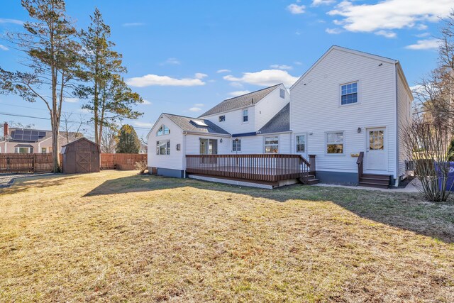 rear view of property with a storage shed, a yard, fence, and an outdoor structure