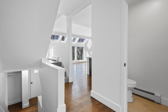 interior space with wood finished floors, baseboards, and a baseboard radiator