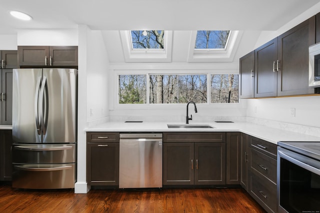 kitchen featuring a sink, appliances with stainless steel finishes, a wealth of natural light, and light countertops