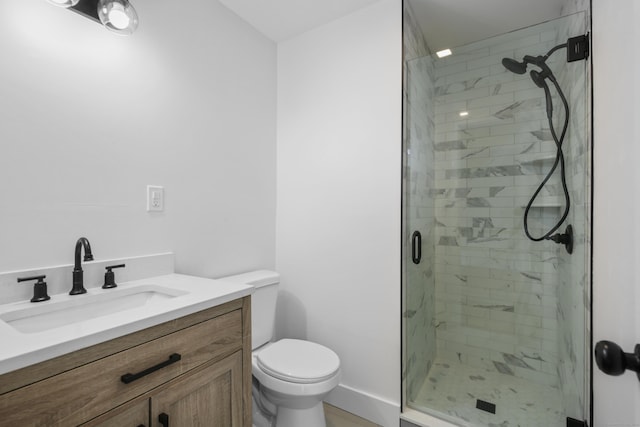 bathroom with toilet, a stall shower, vanity, and baseboards