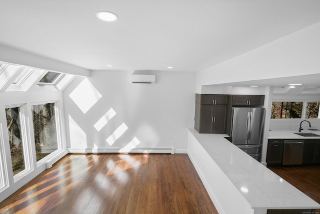 unfurnished living room with lofted ceiling with skylight, dark wood-type flooring, a wealth of natural light, and a sink