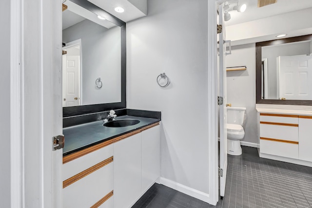 bathroom featuring vanity, visible vents, baseboards, tile patterned floors, and toilet