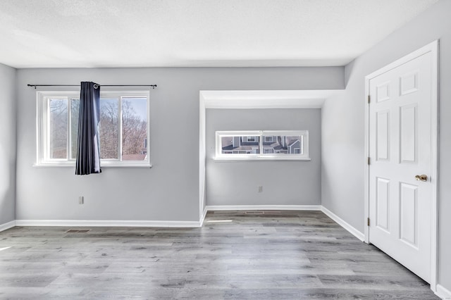 unfurnished bedroom featuring wood finished floors, visible vents, and baseboards