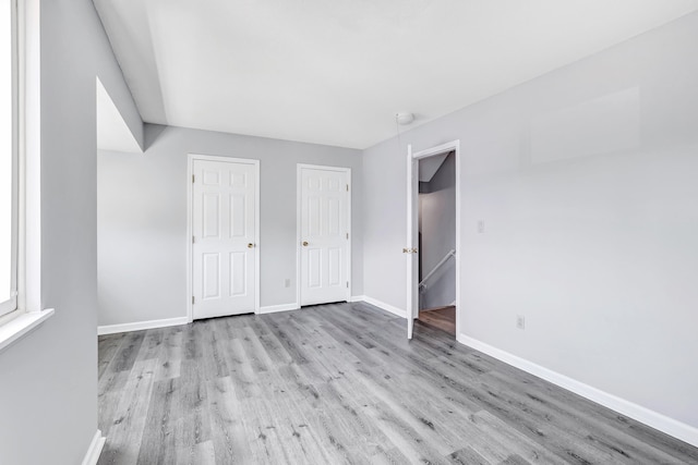 unfurnished bedroom with baseboards and wood finished floors