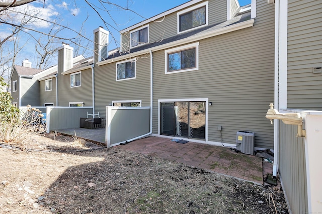 back of property with central AC, a patio, and fence