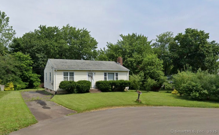 view of front of home featuring aphalt driveway and a front yard