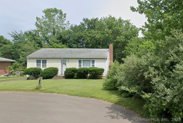 view of front of property featuring a chimney and a front lawn