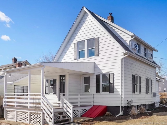 rear view of property featuring covered porch and a chimney