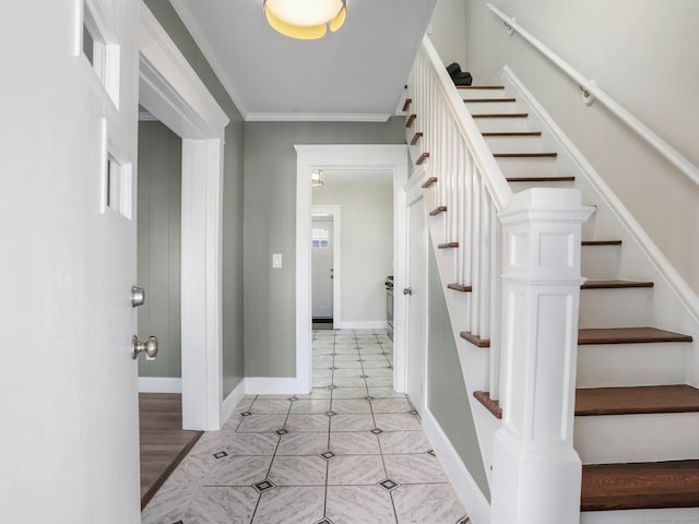 interior space with stairs, baseboards, and ornamental molding