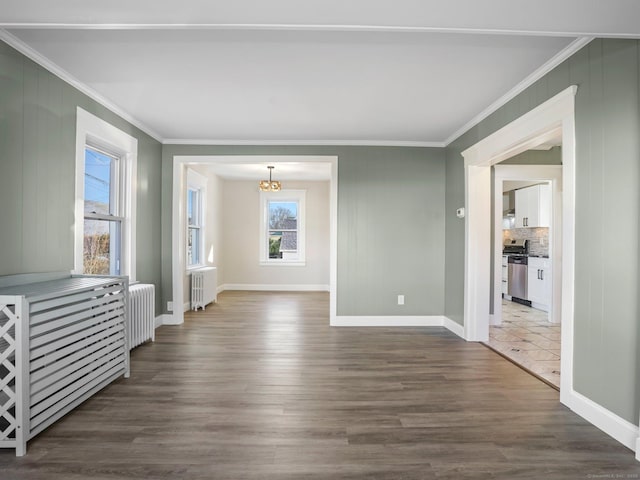 interior space with radiator, ornamental molding, radiator heating unit, and dark wood-style flooring