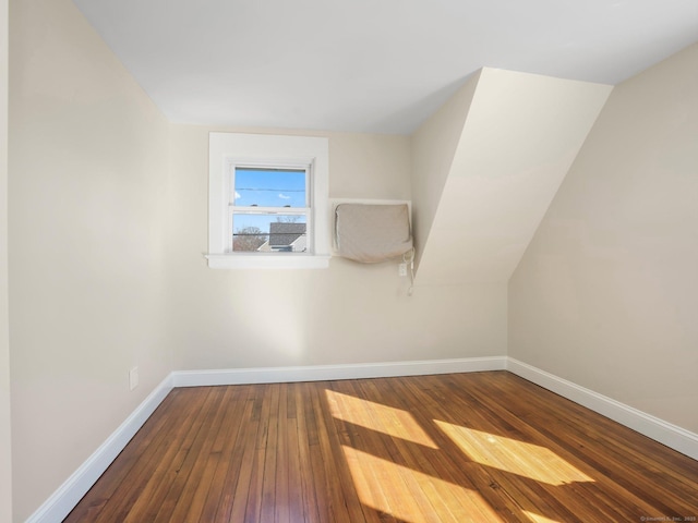 additional living space featuring baseboards and hardwood / wood-style floors