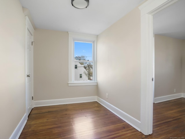 empty room with dark wood-style floors and baseboards