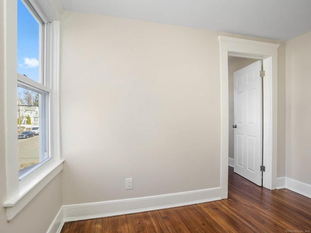 empty room with baseboards and dark wood-style floors