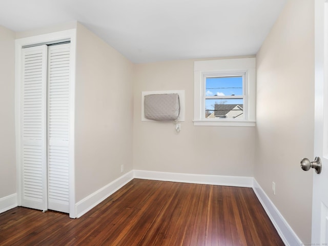 interior space with a closet, baseboards, and dark wood-type flooring