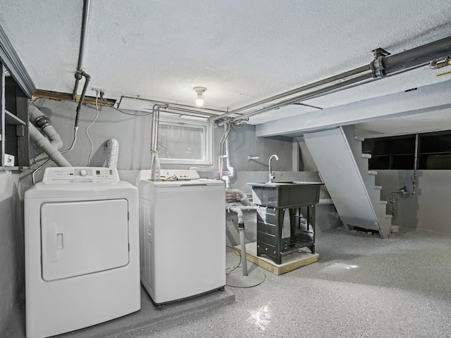 laundry room featuring laundry area, independent washer and dryer, a textured ceiling, and a sink