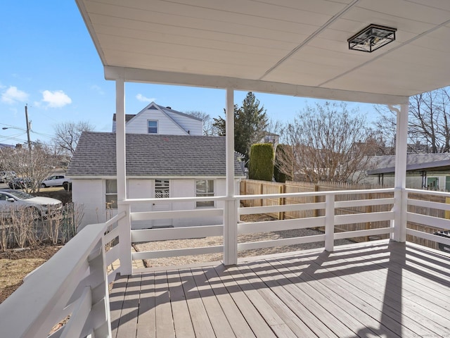 wooden deck featuring an outbuilding and fence