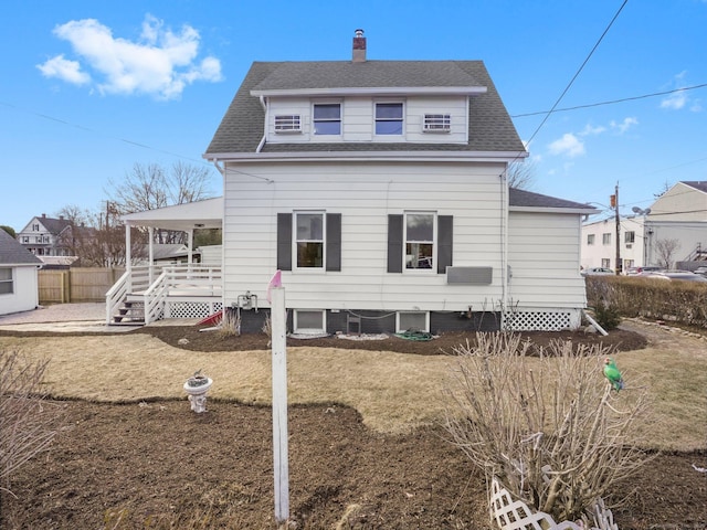 exterior space with a front lawn, fence, and a shingled roof