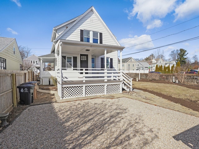 rear view of property with a porch and fence