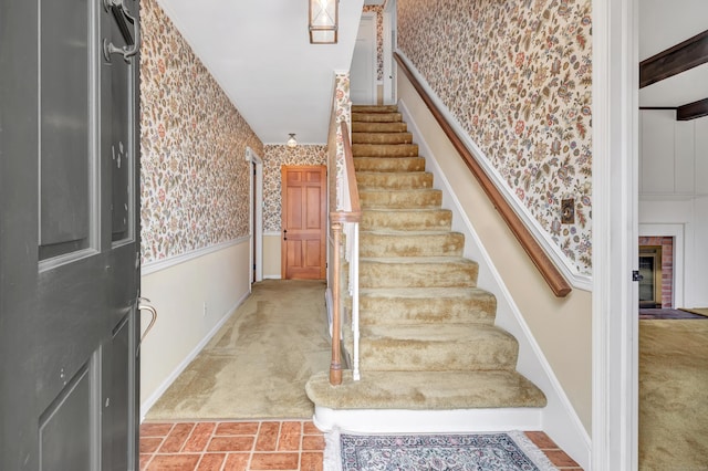 stairs featuring a wainscoted wall, carpet floors, baseboards, and wallpapered walls