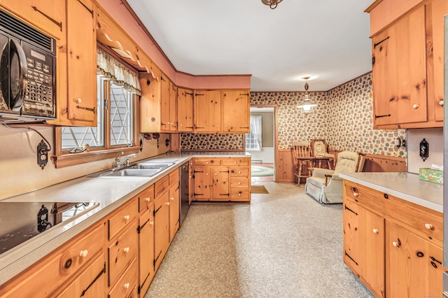 kitchen featuring wallpapered walls, black appliances, a healthy amount of sunlight, and a sink