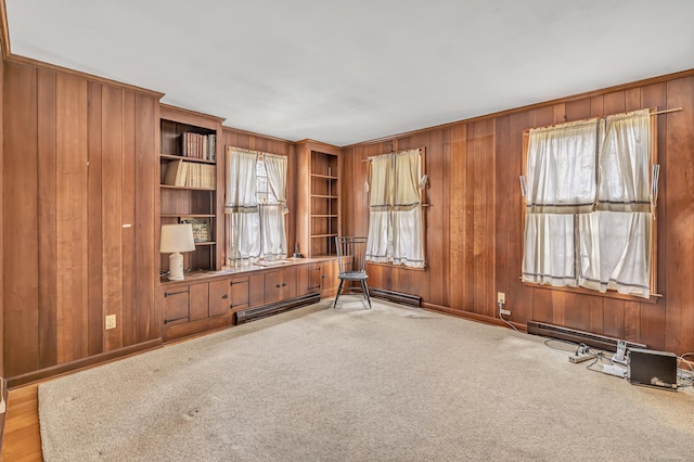 interior space featuring wooden walls, carpet, and baseboard heating