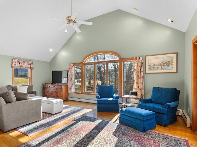 living area featuring baseboard heating, high vaulted ceiling, and wood finished floors