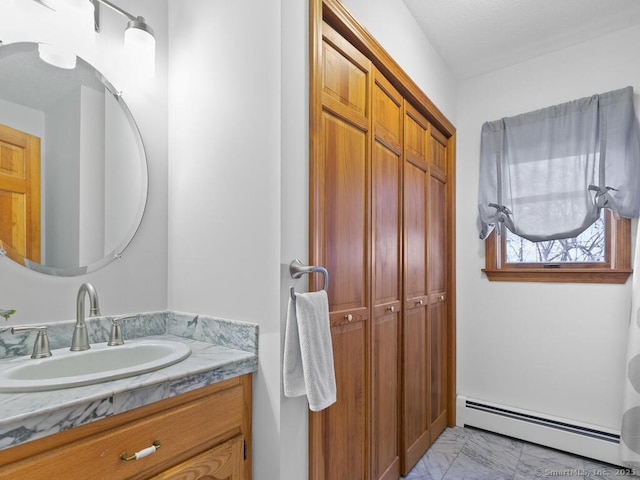 bathroom with baseboard heating, marble finish floor, and vanity