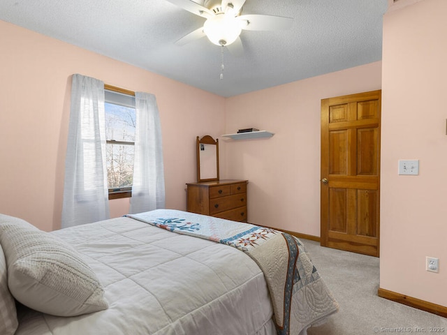 carpeted bedroom with baseboards, a textured ceiling, and ceiling fan