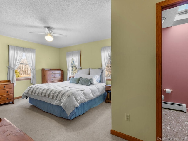 bedroom with a baseboard heating unit, carpet floors, and a textured ceiling