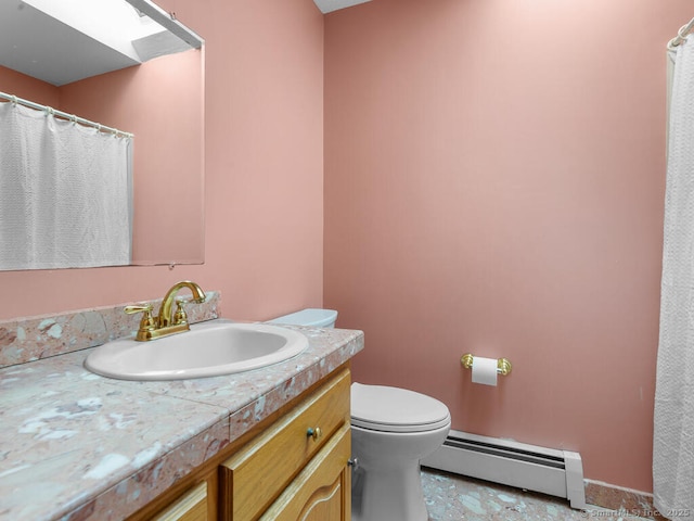 full bath with a skylight, toilet, vanity, and a baseboard heating unit