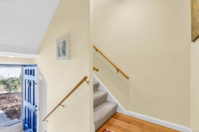 stairs featuring wood finished floors and baseboards