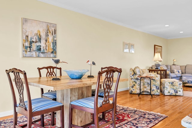 dining room featuring crown molding, baseboards, and wood finished floors