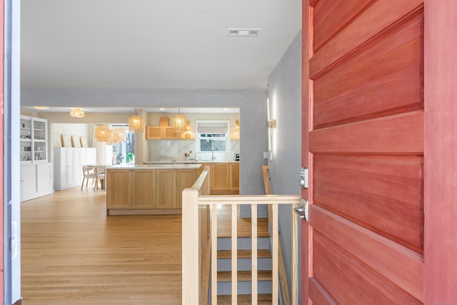 foyer entrance with light wood finished floors and visible vents